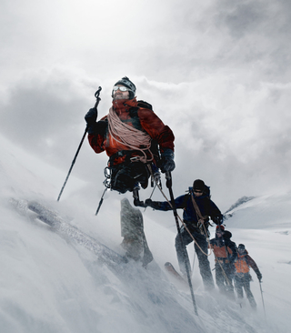 Man leading a team in the snow up a mountain
